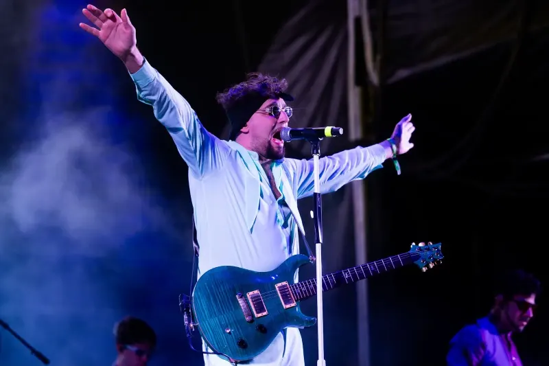 Cantante y guitarrista en el escenario con humo y luz azul